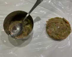 Step <p>Retiramos la masa del vaso y formamos las hamburguesas sobre un film transparente, para que después nos resulte más fácil cogerlas para cocinarlas o bien para dejarlas listas para congelar. Podéis usar un aro como este para darle forma a las hamburguesas sin ensuciarnos las manos.</p> illustration